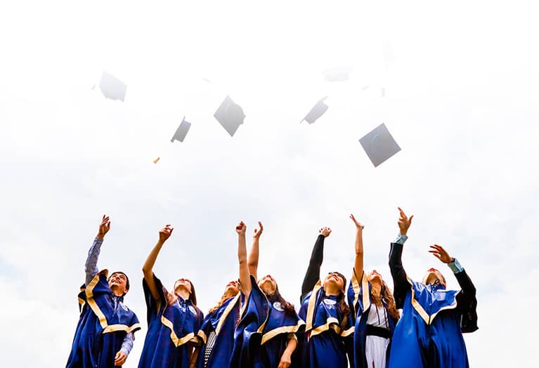 Graduating students throwing caps in the air